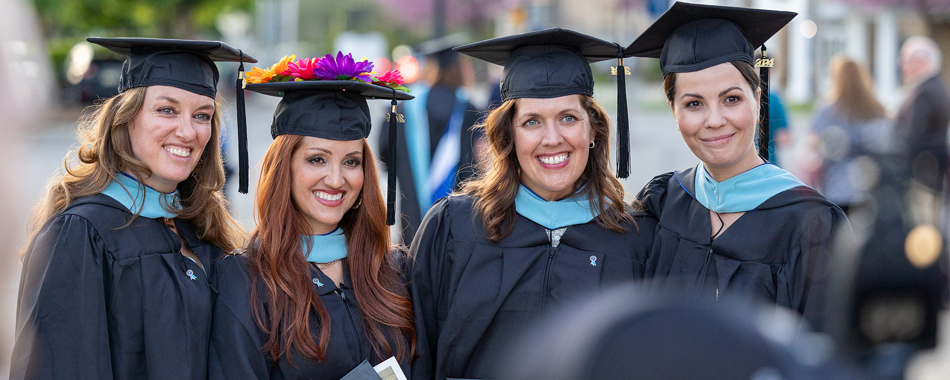certifications women standing outside in regalia