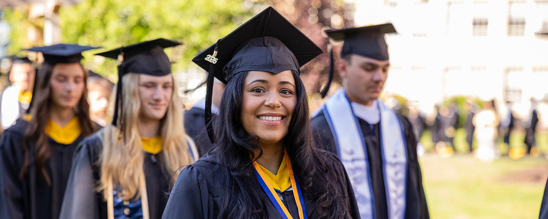 women wearing graduation cap and gown surrounded by other student graduates