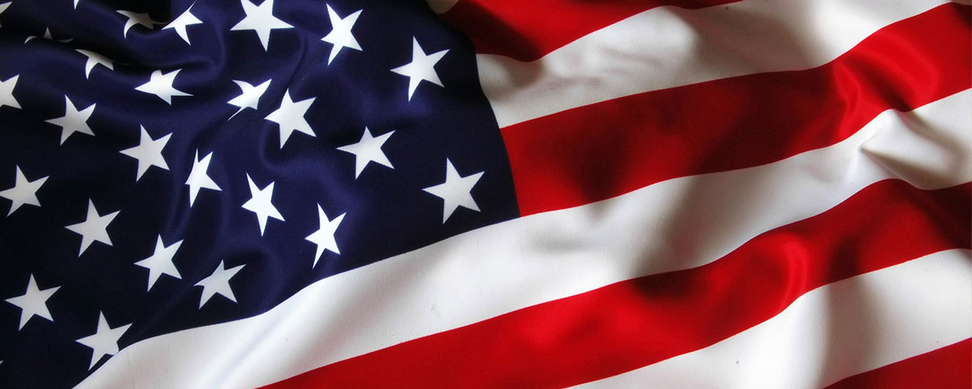 Close-up of a waving United States flag with soft ripples in the fabric.